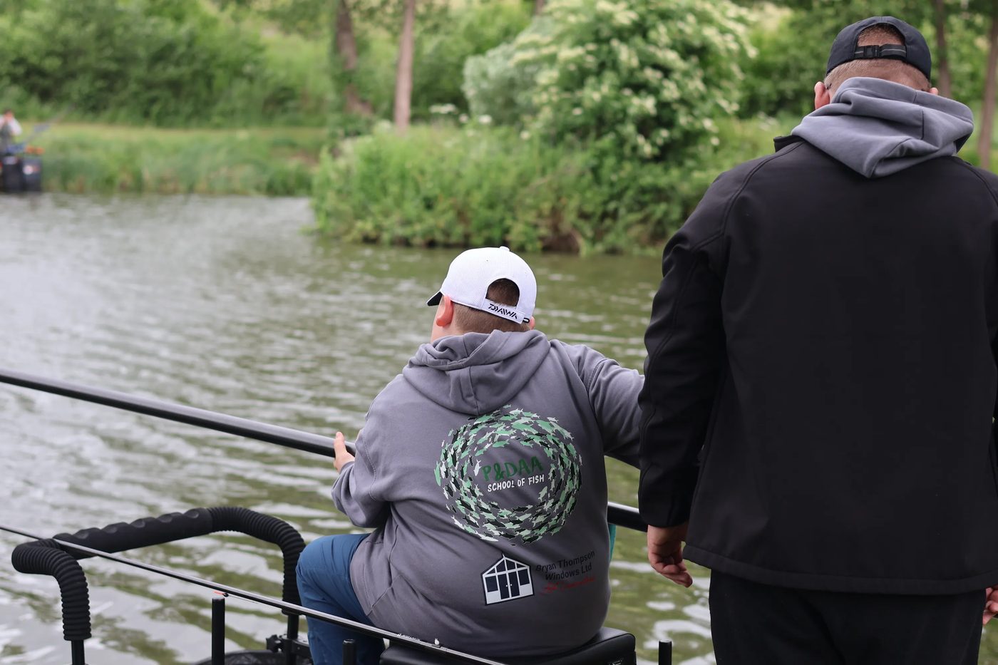 A young angler on the bank with a coach