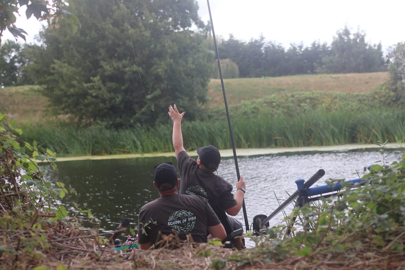 A young angler swinging a pole rig out over the water at a coached session