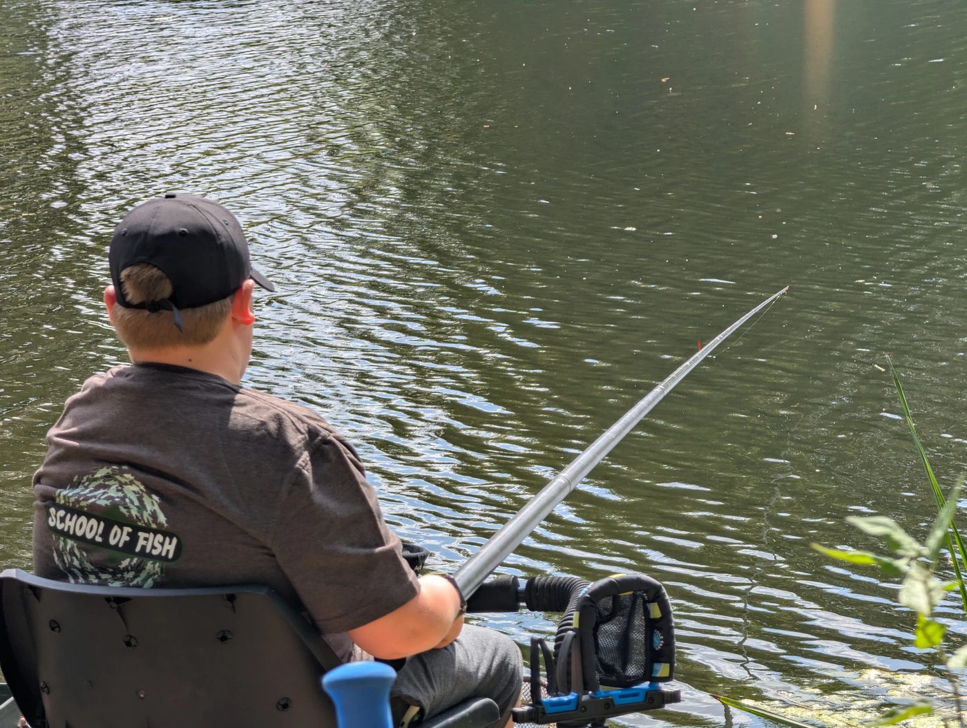 A young angler in School Of Fish colours watching the float on the pole